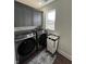 Bright laundry room featuring a new washer and dryer, as well as cabinets and a window for natural light at 2029 Winton Ave, Indianapolis, IN 46224