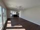 Bright and open living room with hardwood floors, recessed lighting and white ceiling fan leading into kitchen at 2029 Winton Ave, Indianapolis, IN 46224