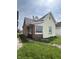 Exterior view of a home showing the siding, windows, and compact yard with scattered dandelions at 2157 S Meridian St, Indianapolis, IN 46225