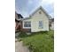 The home's facade features aged siding, a large window, and a small yard with scattered dandelions at 2157 S Meridian St, Indianapolis, IN 46225