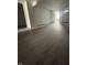 Open-concept living room with new wood-look flooring, neutral walls, and ample natural light, staged for renovation at 2157 S Meridian St, Indianapolis, IN 46225