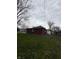 Backyard view of the detached garage/shed, situated on a well-maintained green lot at 216 Golf Club Rd, Anderson, IN 46011