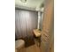 Functional bathroom features a compact sink, toilet, and shower with gray curtain at 216 Golf Club Rd, Anderson, IN 46011