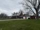 Exterior of the two-story home with brick and white siding, a long driveway, and an attached two-car garage at 216 Golf Club Rd, Anderson, IN 46011