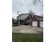 Side view of the brick house, showing the covered porch, large parking pad, and detached two-car garage at 216 Golf Club Rd, Anderson, IN 46011