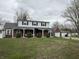 Charming two-story home with brick and white siding, a covered front porch, and well-maintained landscaping at 216 Golf Club Rd, Anderson, IN 46011