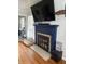 Stylish fireplace with a blue mantel, decorative tile, and hardwood floors, adding warmth to the room at 216 Golf Club Rd, Anderson, IN 46011