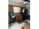 Functional kitchen with wood cabinets, black appliances, and a double sink under a bright window at 216 Golf Club Rd, Anderson, IN 46011