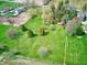 Wide aerial shot capturing sprawling green fields, mature trees, and a charming property at 2215 W State Rd, Pendleton, IN 46064