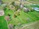 Lush aerial view displaying sprawling green fields and mature trees surrounding a quaint property at 2215 W State Rd, Pendleton, IN 46064