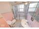 Neat bathroom offers a glass-enclosed shower, pedestal sink, toilet, and pink tiling at 2215 W State Rd, Pendleton, IN 46064