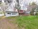 Exterior view of a home featuring a garage, sunroom, and a well-manicured lawn at 2215 W State Rd, Pendleton, IN 46064