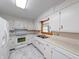 Well-lit kitchen equipped with white cabinetry, marble tile flooring, and modern appliances at 2215 W State Rd, Pendleton, IN 46064