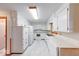 Clean kitchen offers white cabinets, marble tile floors, and updated appliances for modern convenience at 2215 W State Rd, Pendleton, IN 46064