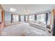 Bright sunroom with multiple windows offering natural light, plush carpeting, and brick accent wall at 2215 W State Rd, Pendleton, IN 46064