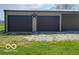 Garage with two doors, decorated with a star, gravel area, and dandelions at 2227 S County Road 300 E, Danville, IN 46122
