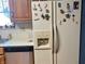 Kitchen with white fridge decorated with magnets, stainless steel dishwasher, wood cabinets at 2227 S County Road 300 E, Danville, IN 46122