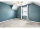 A carpeted bedroom with blue walls and angled ceilings has a window at 2615 N Delaware St, Indianapolis, IN 46205