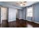 This is a bedroom with a ceiling fan, hardwood floors, blue walls, and an entrance to another room at 2615 N Delaware St, Indianapolis, IN 46205