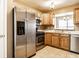Traditional kitchen with stainless steel appliances, tiled floor, and light wood cabinets at 2615 N Delaware St, Indianapolis, IN 46205