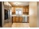 Traditional-style kitchen with stainless steel appliances, natural wood cabinets, and tiled flooring at 2615 N Delaware St, Indianapolis, IN 46205