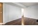 Empty living room with hardwood floors and white walls and a doorway at 2615 N Delaware St, Indianapolis, IN 46205