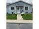 Inviting front porch with a decorative wreath, a chair, potted plants, and a well-manicured lawn at 2715 Prosperity Dr, Columbus, IN 47201