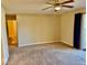 Spacious carpeted bedroom featuring a ceiling fan and access to an ensuite bathroom and outdoor patio at 305 S Schroeder Rd, Muncie, IN 47304
