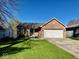 Charming brick home featuring a well-maintained lawn, attached garage, and inviting front porch at 305 S Schroeder Rd, Muncie, IN 47304