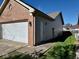 Side exterior of home, showing the attached garage, clean siding, and a well-manicured lawn at 305 S Schroeder Rd, Muncie, IN 47304