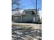 View of the back of the house with a grassy area and gravel parking at 312 S Gharkey St, Muncie, IN 47305