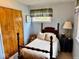 Bright bedroom featuring a wood-framed bed, bedside table with lamp, and closet at 3601 N Oakwood Ave, Muncie, IN 47304