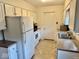 Efficient kitchen featuring white cabinetry, appliances, and neutral countertops and flooring at 3601 N Oakwood Ave, Muncie, IN 47304
