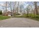 View of driveway leading to a house surrounded by trees at 3636 E 71St St, Indianapolis, IN 46220
