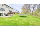 Lush backyard with green grass, mature trees, a patio, a trampoline and distant views of neighboring houses at 3724 Jonathan Rdg, Columbus, IN 47201