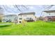 Spacious backyard featuring a well-manicured lawn, a deck, and mature trees with neighboring houses in the background at 3724 Jonathan Rdg, Columbus, IN 47201