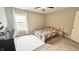 Cozy bedroom with a ceiling fan, a bed with floral sheets, neutral walls, and natural light from a large window at 3724 Jonathan Rdg, Columbus, IN 47201