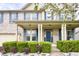Inviting two-story home featuring a covered front porch, brick facade, blue door and shutters, and manicured landscaping at 3724 Jonathan Rdg, Columbus, IN 47201