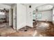 This damaged living room features peeling paint, holes in the floor, and dated fixtures at 3845 E 32Nd St, Indianapolis, IN 46218