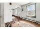 This fixer-upper living room features peeling paint, damaged floors, and outdated windows at 3845 E 32Nd St, Indianapolis, IN 46218