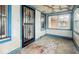 Shows the sunroom with its ornate security door and window bars offering a view of the street at 3845 E 32Nd St, Indianapolis, IN 46218