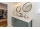 Modern bathroom with double sink vanity, round mirrors, contemporary lighting, and walk-in closet at 402 E 46Th St, Indianapolis, IN 46205