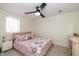 Cozy bedroom featuring a ceiling fan, a window with curtains and a bed with soft pillows at 402 E 46Th St, Indianapolis, IN 46205
