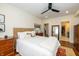 Bright bedroom with neutral walls, ceiling fan, wood floors, en-suite bathroom, and classic-style furnishings at 402 E 46Th St, Indianapolis, IN 46205