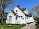 Side view of white brick home with green lawn, flowers and small landscaped area at 402 E 46Th St, Indianapolis, IN 46205