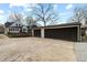 Spacious two-car garage with dark doors and concrete driveway next to a home with a yard at 402 E 46Th St, Indianapolis, IN 46205