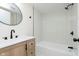 Stylish bathroom featuring modern vanity, sleek fixtures, a tub with shower, and elegant tiling at 402 N 19Th Ave, Beech Grove, IN 46107