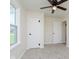 Neutral bedroom features a ceiling fan, carpet, white trim, and ample natural light from the window at 402 N 19Th Ave, Beech Grove, IN 46107