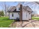 Rear view of a white two-story home with a brick chimney and manicured lawn at 402 N 19Th Ave, Beech Grove, IN 46107