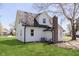 Rear view of a white two-story home with a brick chimney and manicured lawn at 402 N 19Th Ave, Beech Grove, IN 46107
